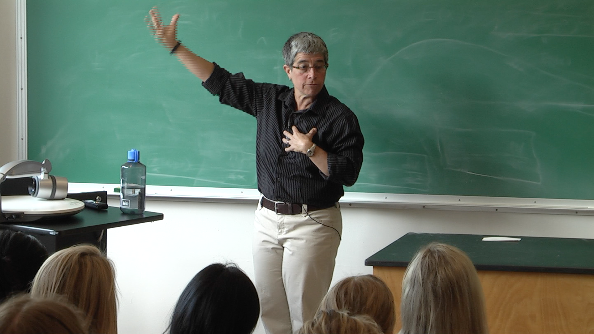 Teacher in front of a black board teaching
